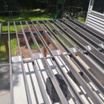 Professional installation of galvanized steel deck framing showing perfectly straight joists with powder-coated finish and consistent spacing for long-term durability