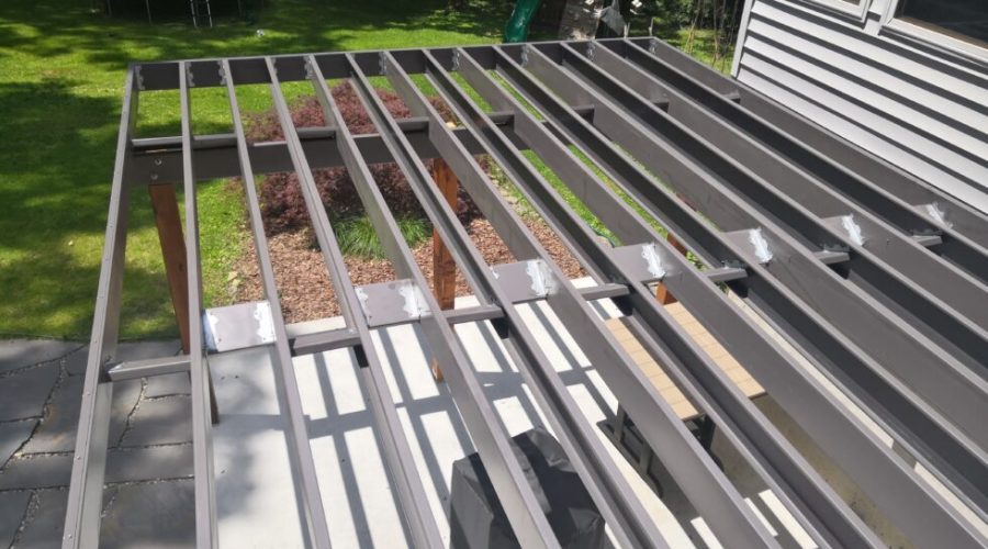 Professional installation of galvanized steel deck framing showing perfectly straight joists with powder-coated finish and consistent spacing for long-term durability