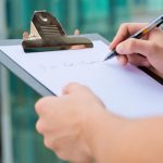 Homeowner reviewing a checklist for hiring an outdoor living contractor on a backyard deck project in Cincinnati OH